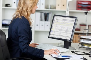 Side view portrait of businesswoman using computer at office desk-1